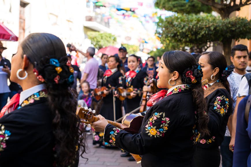 A mariachi group plays music in front of a crowd