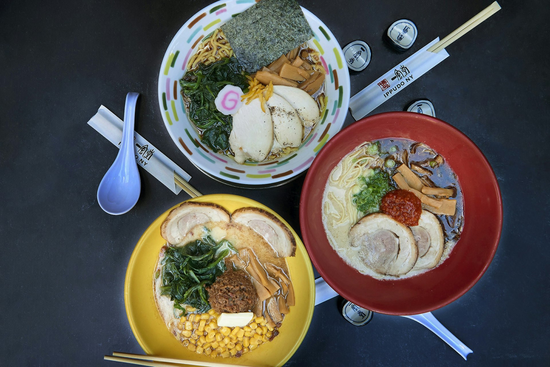 Three colorful bowls of ramen photographed from above