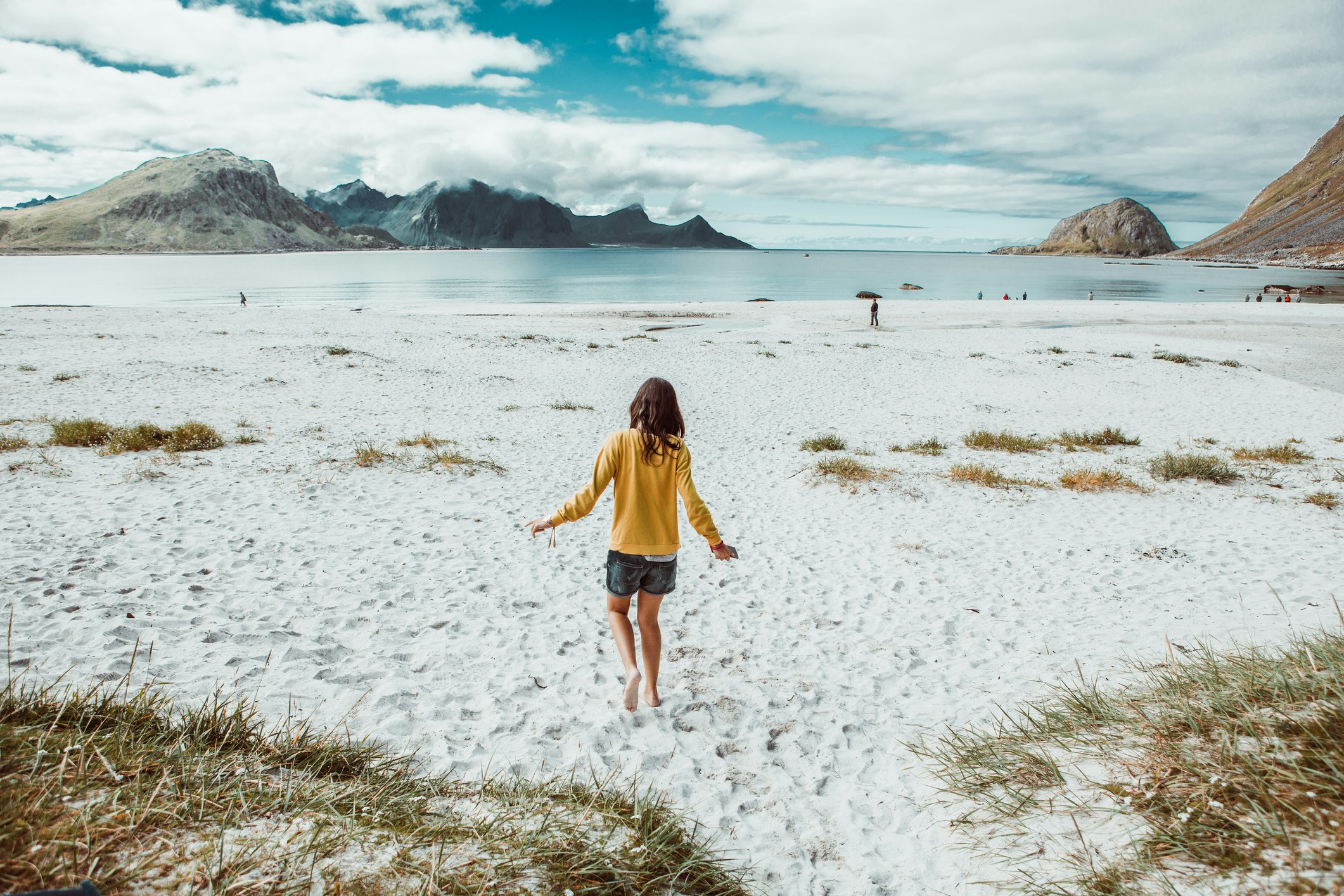 Rear image of teen walking alone in a remote beach in Norway