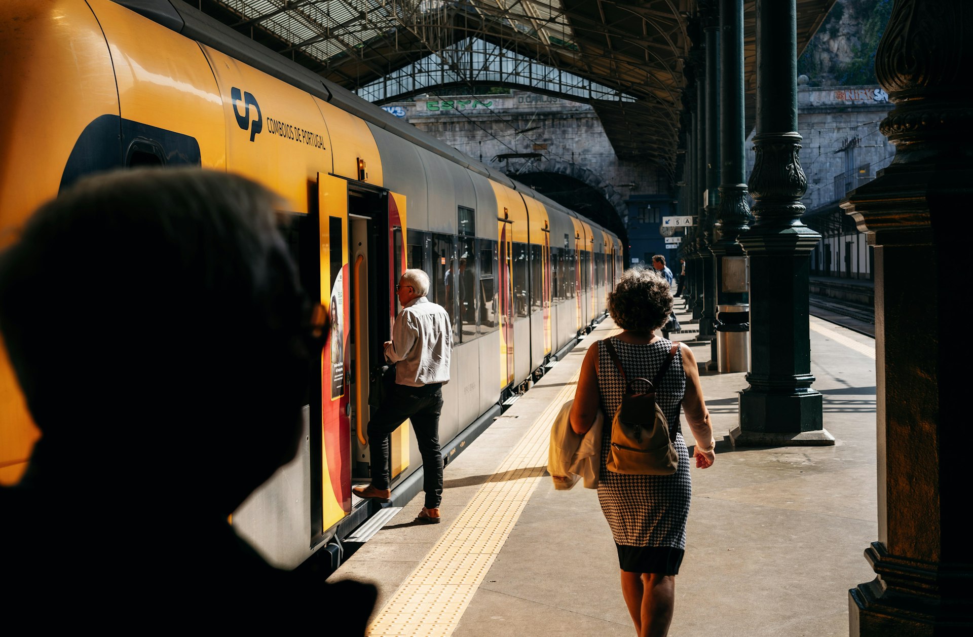 People enter into train in trainstation on summer day, Portugal