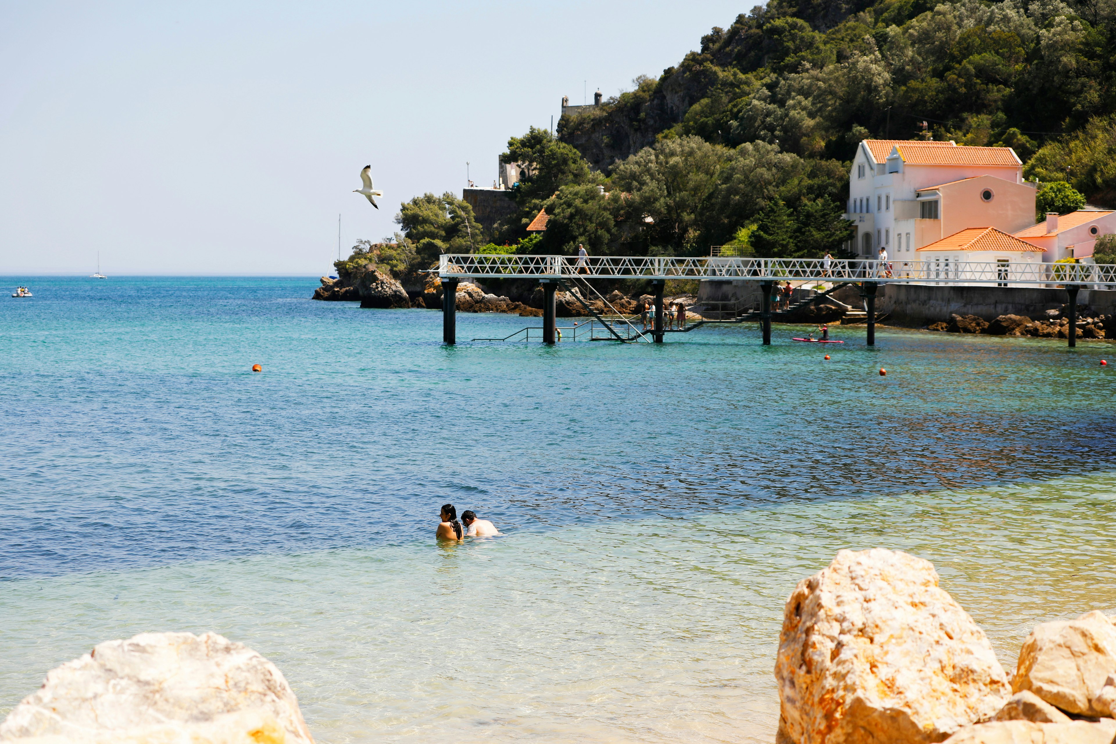 People swim in the water at the beach at Parque Natural da Arrábida, Setubal, Portugal, Europe