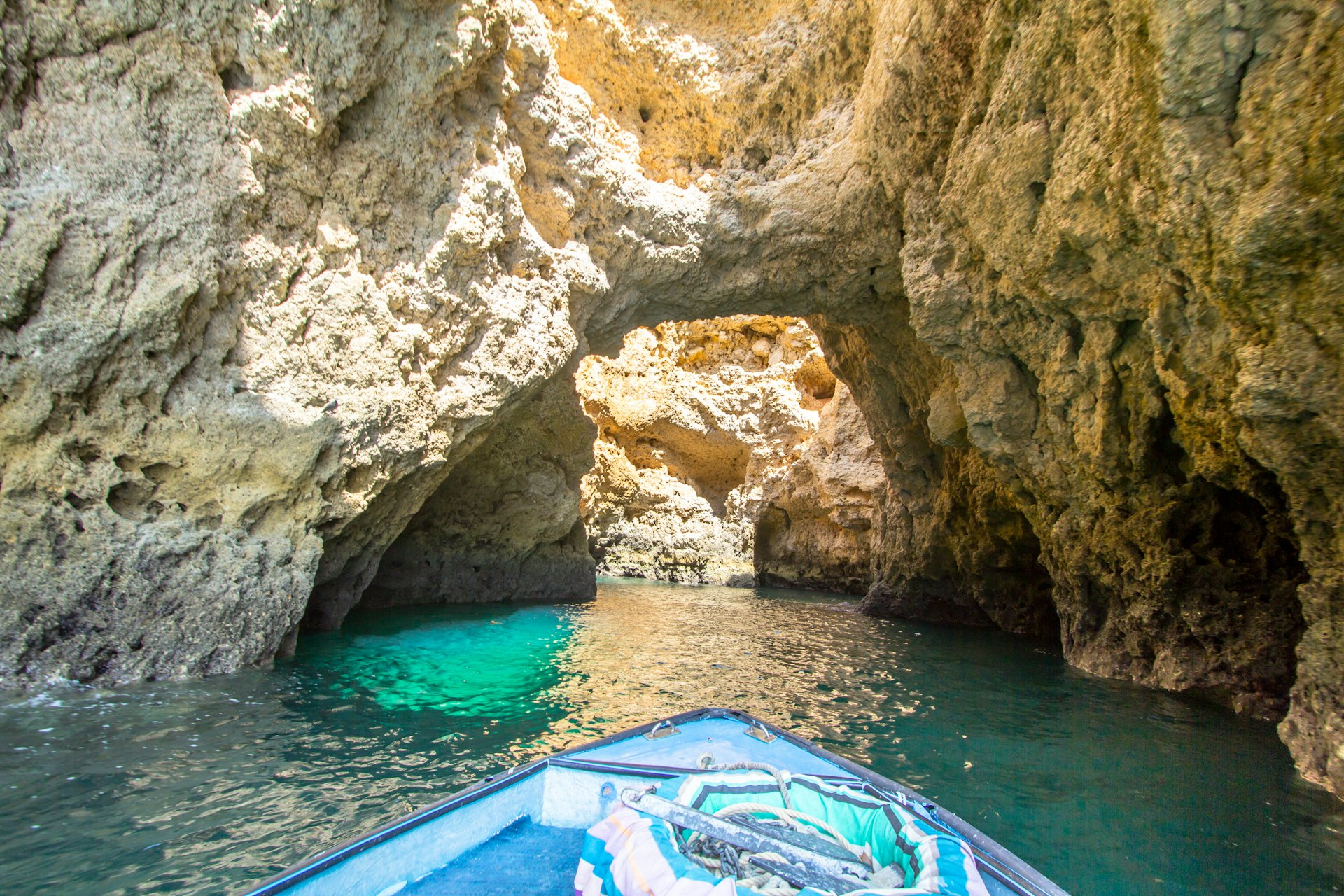 View from a boat on narrow blue waters between the cliffs of the Ponta da Piedade