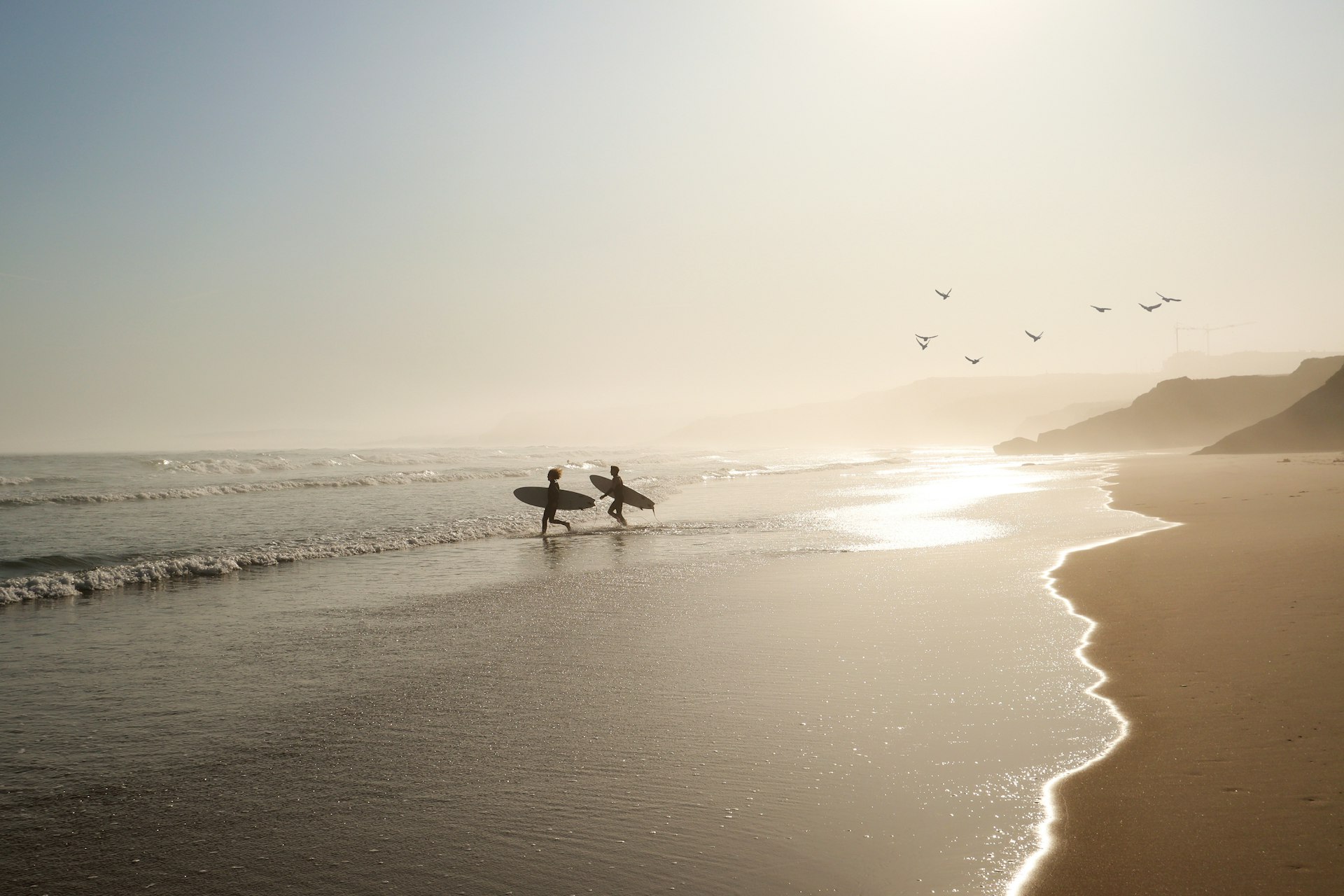 Серферы на пляже в Прайя-Лагиде, Португалия