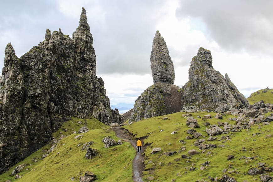 Girl hiking towards The Old Man of Storr, Scotland