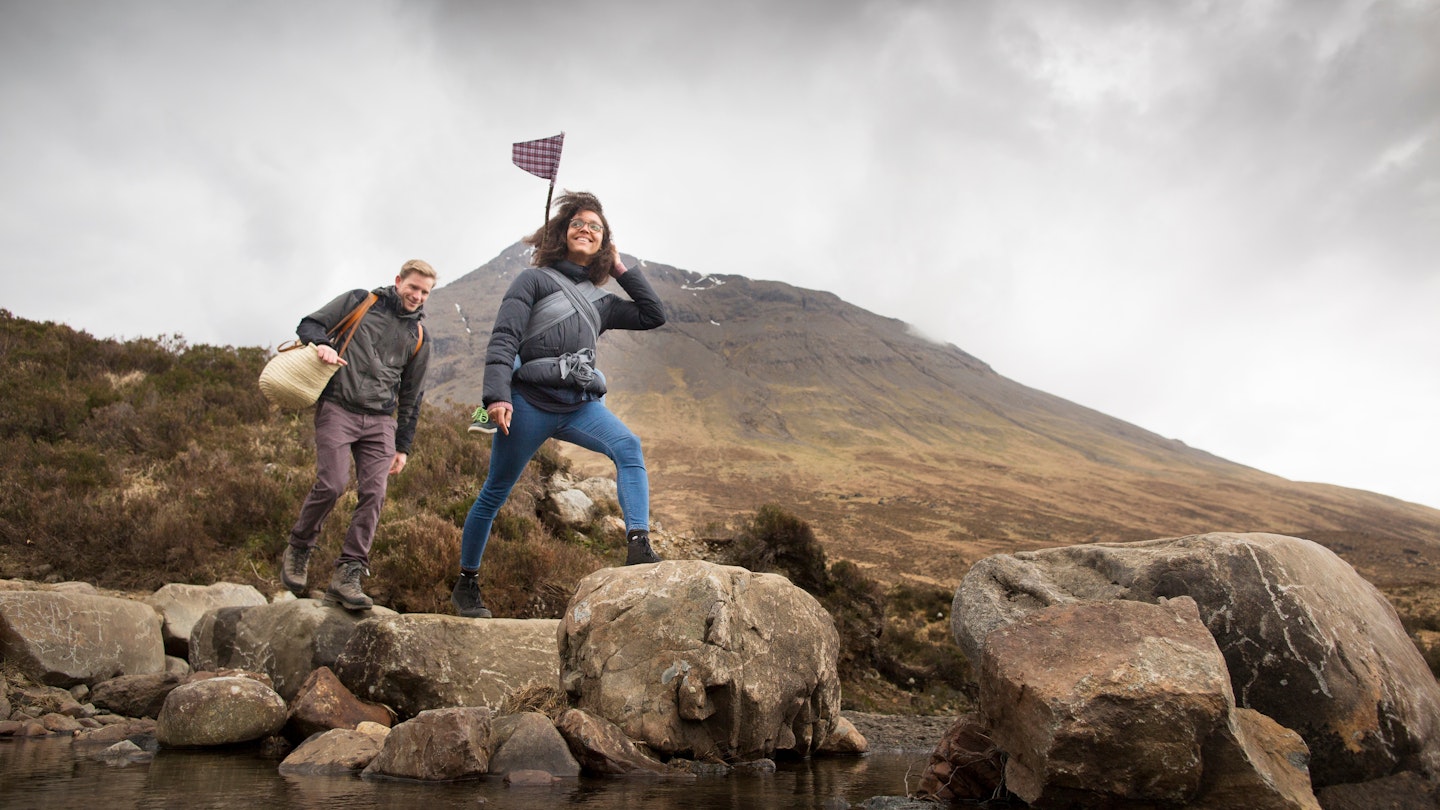 Couple crossing river, Fairy Pools, near Glenbrittle, Isle of Skye, Hebrides, Scotland