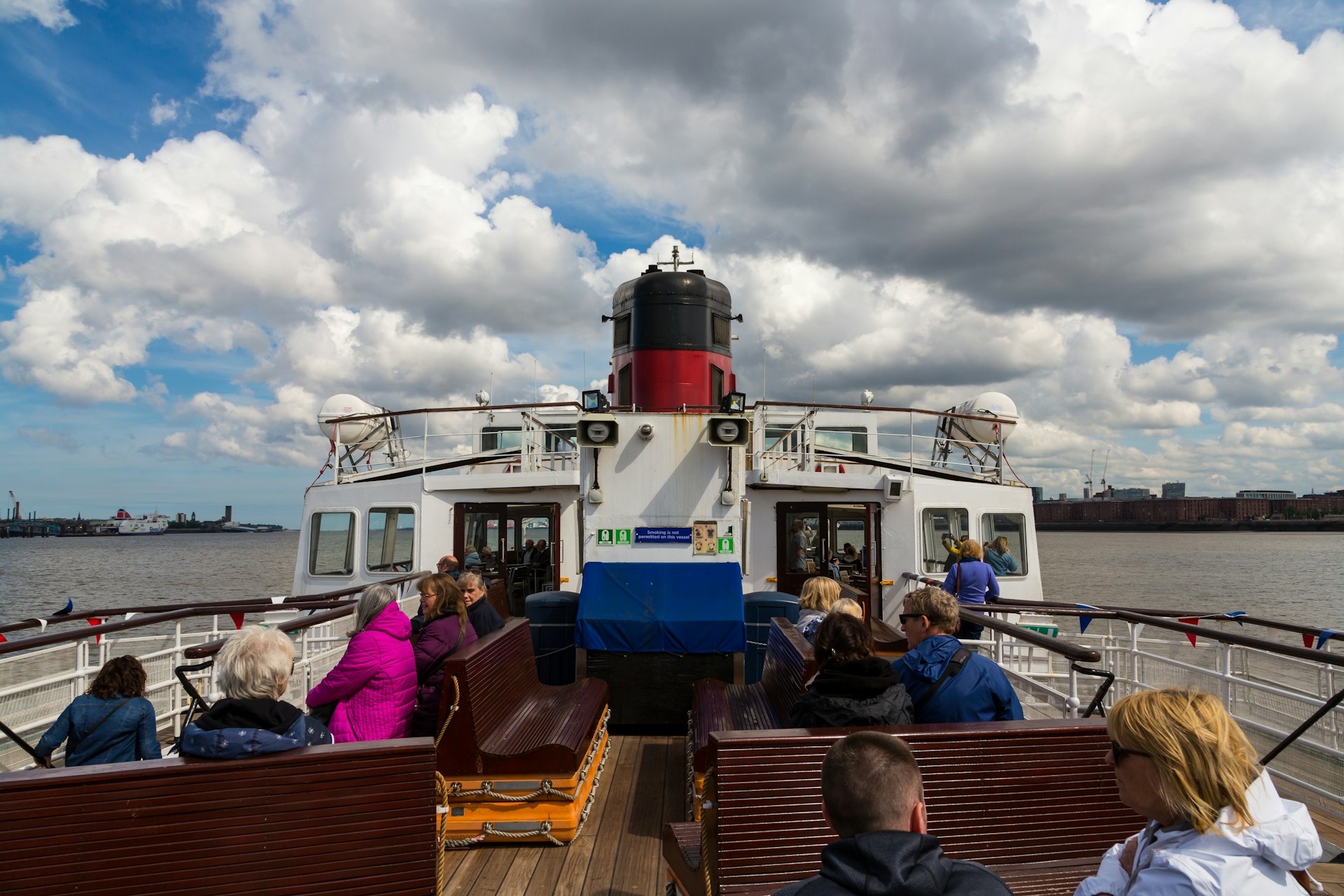 Passengers sit on the on the Mersey Ferry in Liverpool as it crosses the River Mersey