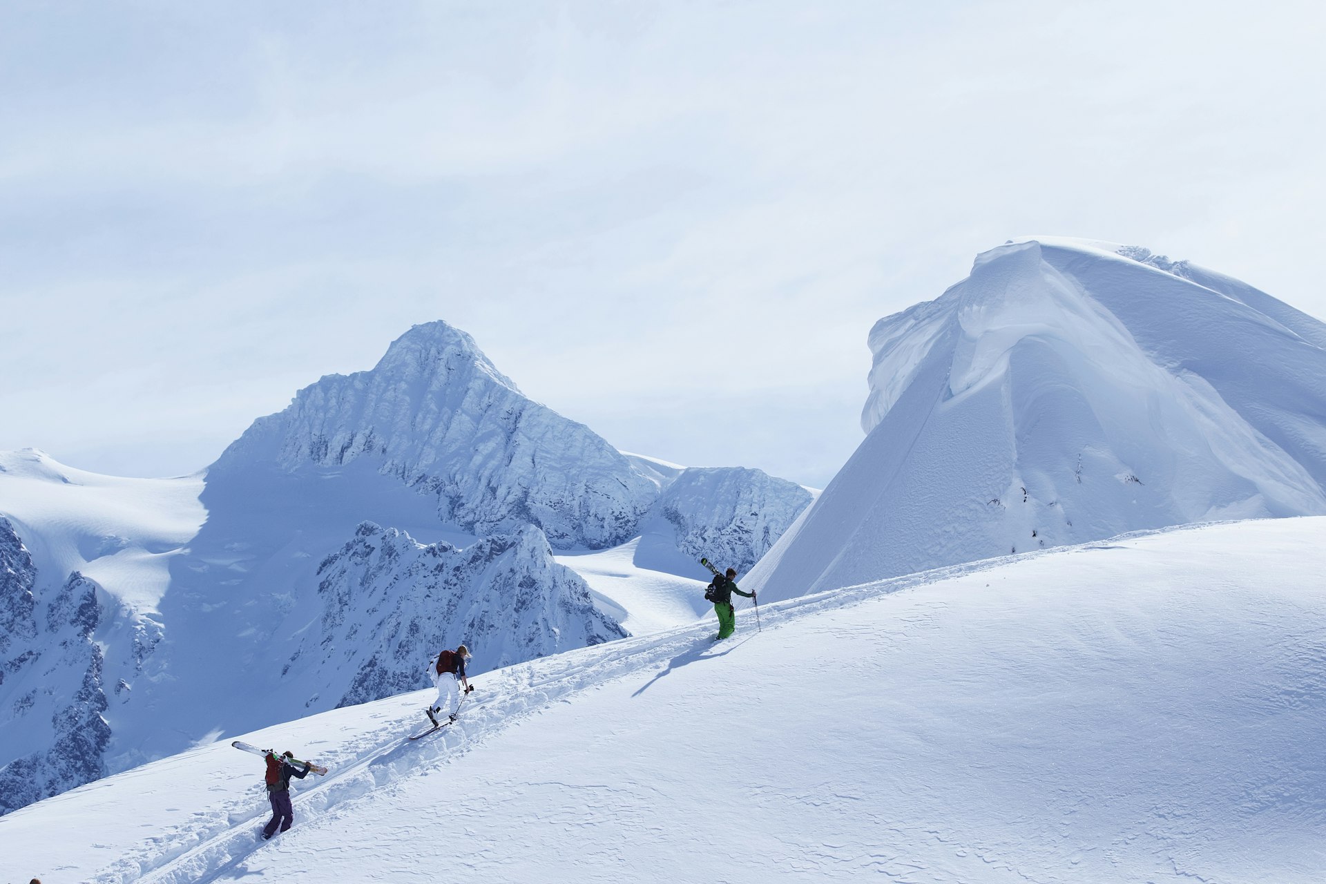 Skiers climbing snowy slope