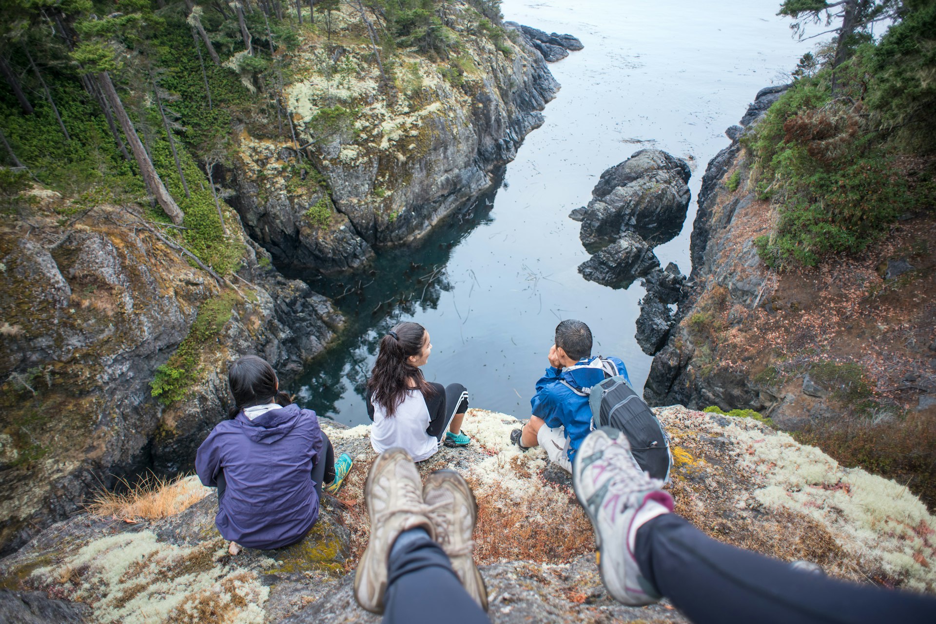 POV, Multi-Ethnic Family of Hikers Resting on Rocky Sea Bluff