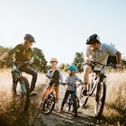 A father and mother ride mountain bikes together with their two small children.  A fun way to spend time together and exercise while on vacation in the Seattle, Washington area.