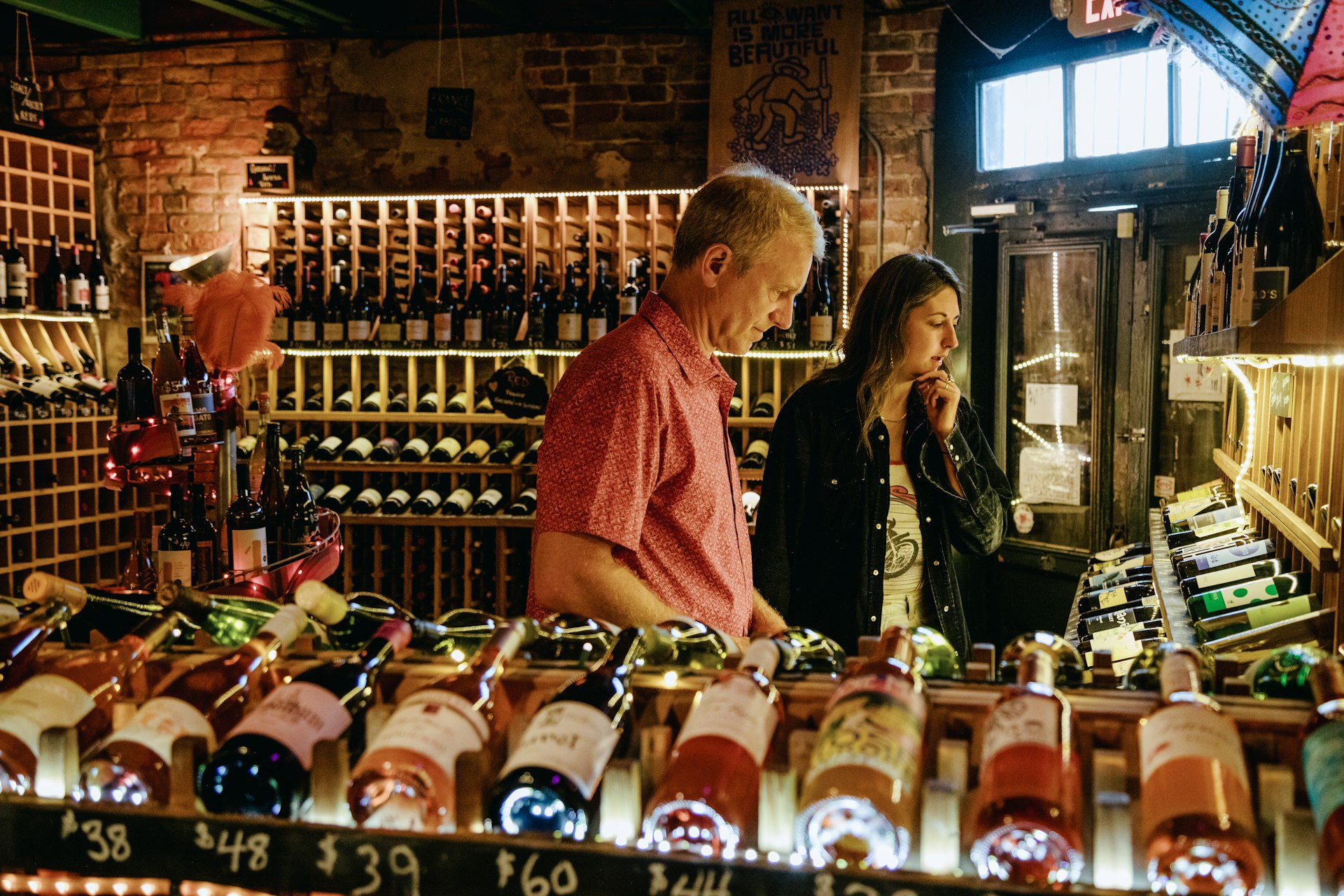 An employee helps a customer find a bottle of wine in the wine shop at Bacchanal, a restaurant, wine bar, and venue located in the Bywater. A small speakeasy-style restaurant that started before Hurricane Katrina © Bryan Tarnowski / Lonely Planet