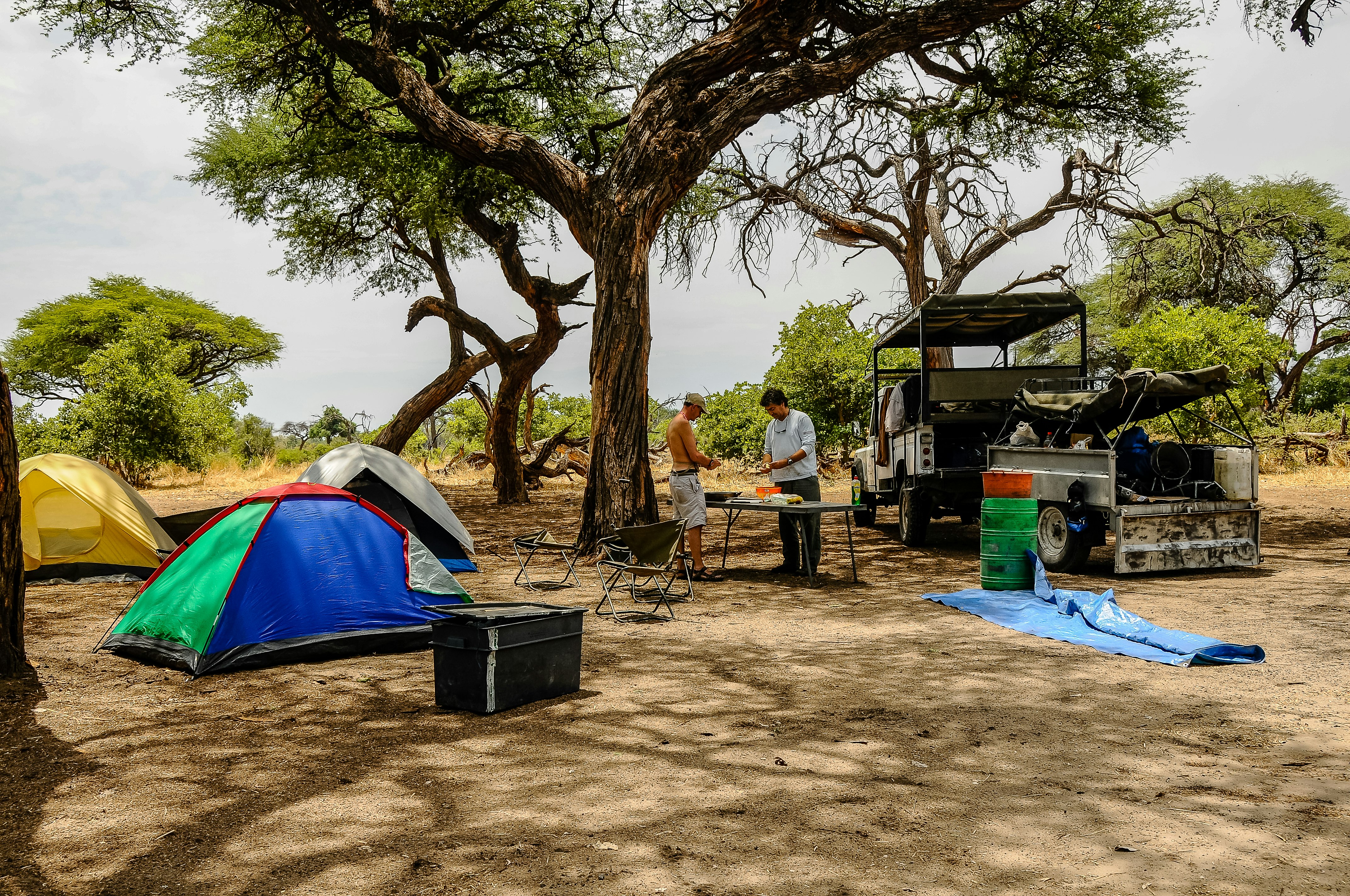 Two travelers prepare lunch after preparing a tent camp in Chobe National Park, Botswana, Africa