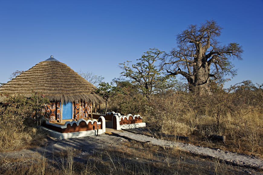Thatched roof hut painted with traditional Bakalanga decorative designs.  Planet Baobab, Botswana.  (PR: property release)