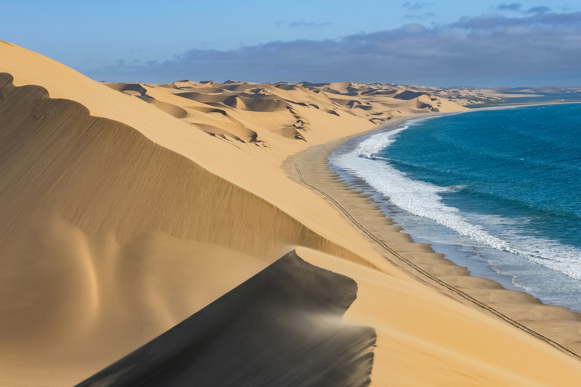 Yellow dunes of the Namib desert fall into the Atlantic Ocean, near Swakopmund, Namibia