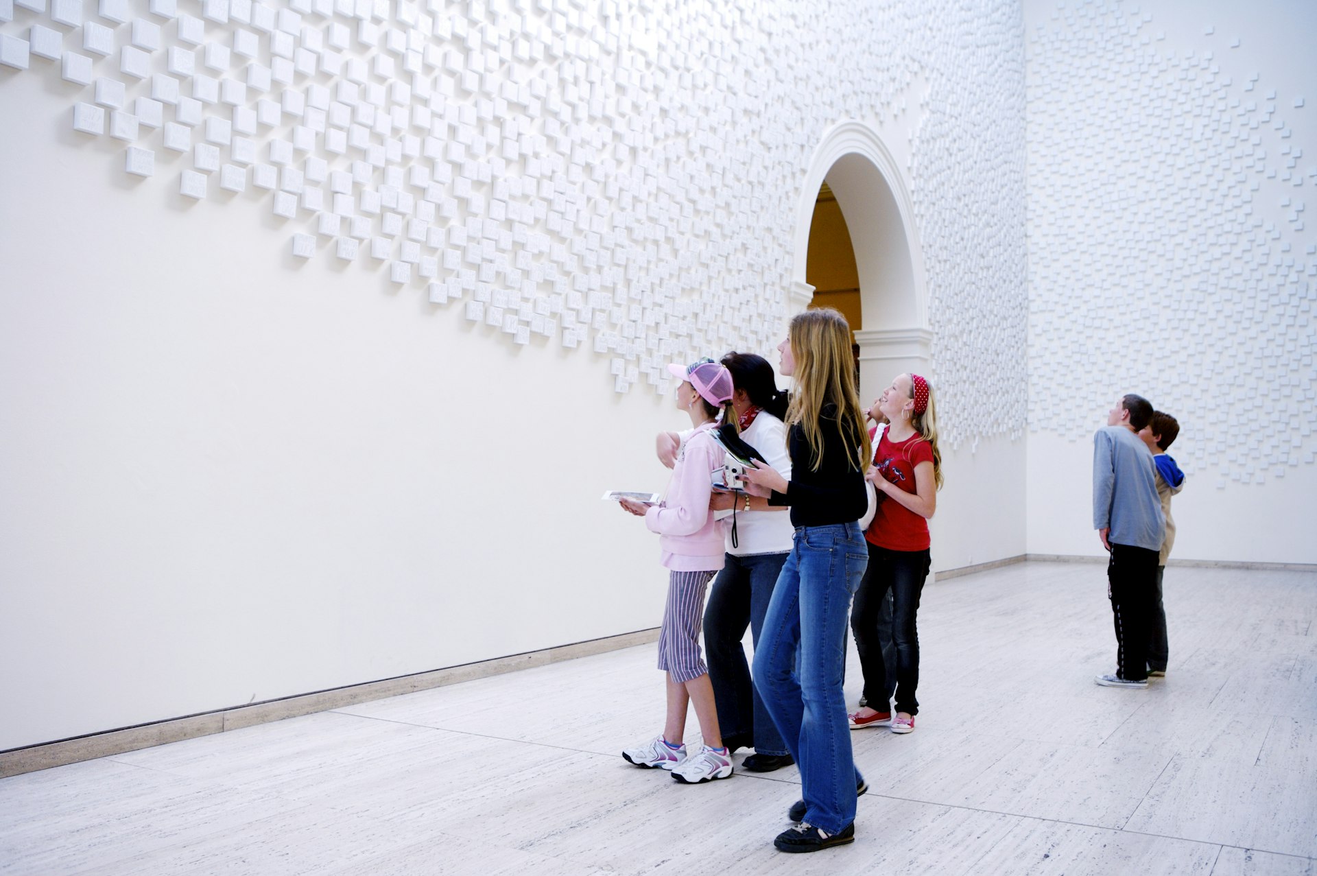 A groupd of young people look at artworks in a city gallery