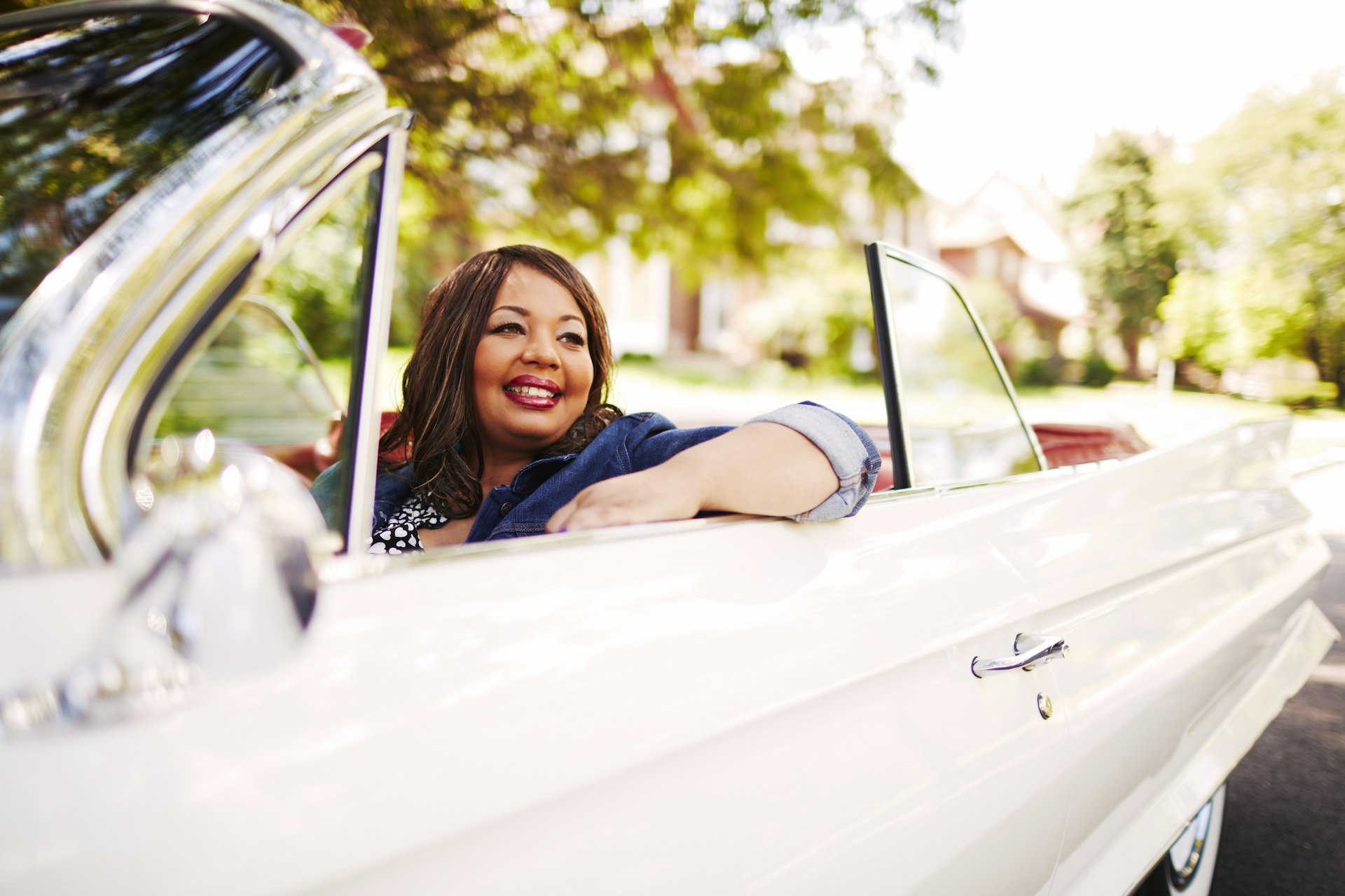 Woman sitting in vintage convertible car in Detroit, Michigan