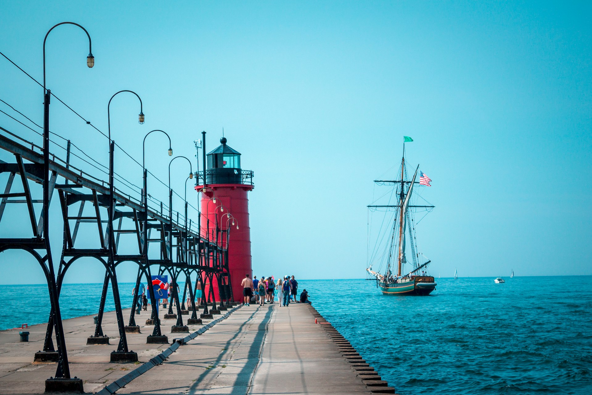 Tall ship sailing past a lighthouse on a summer day on Lake Michigan