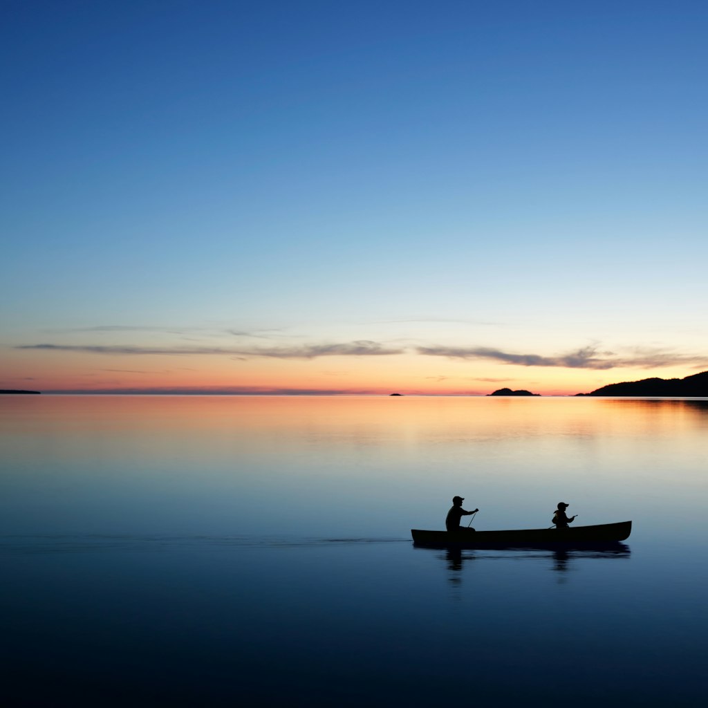 Man and son canoeing on Lake Michigan at dusk.
