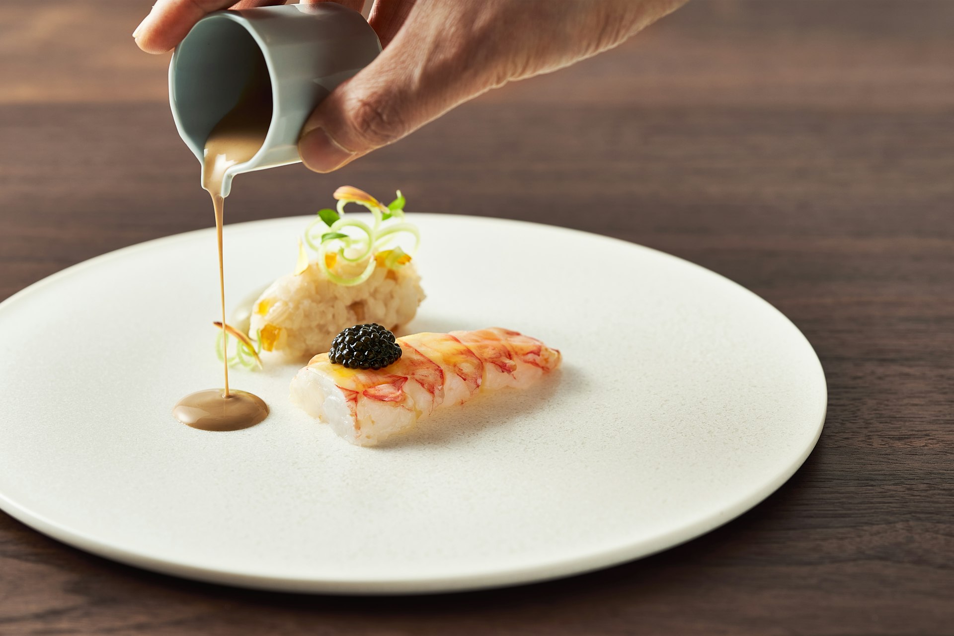 Pouring sauce on a dish of lobster at Mingles restaurant in Seoul, South Korea