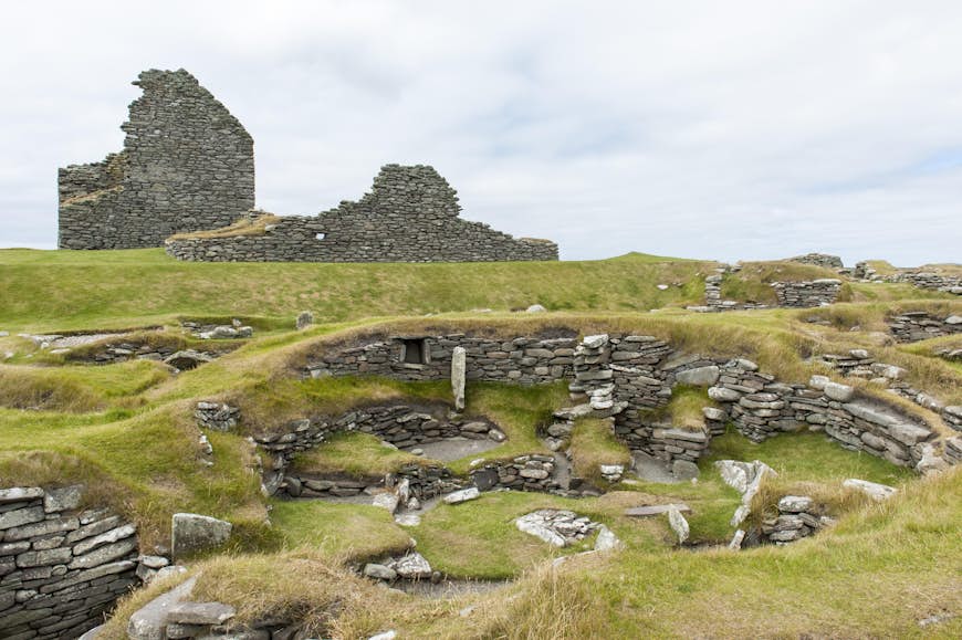 Archaeology, prehistoric archaeological site, Bronze Age building in front, half-destroyed broch in back, Jarlshof, Mainland, Shetland Islands, Scotland, United Kingdom