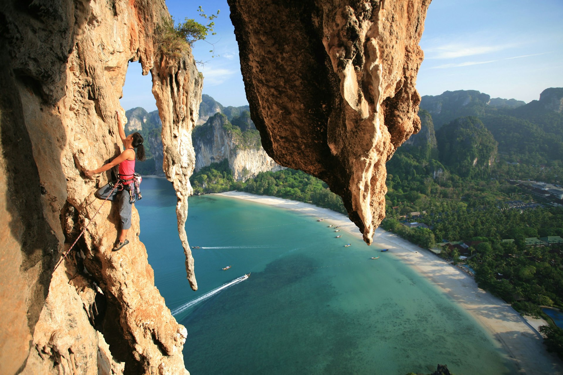A climber on cliffs high above the sea in Thailand