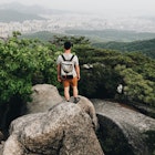 Young Man Hiking In Bukhansan National Park View Looking Out To The City Of Seoul South Korea

