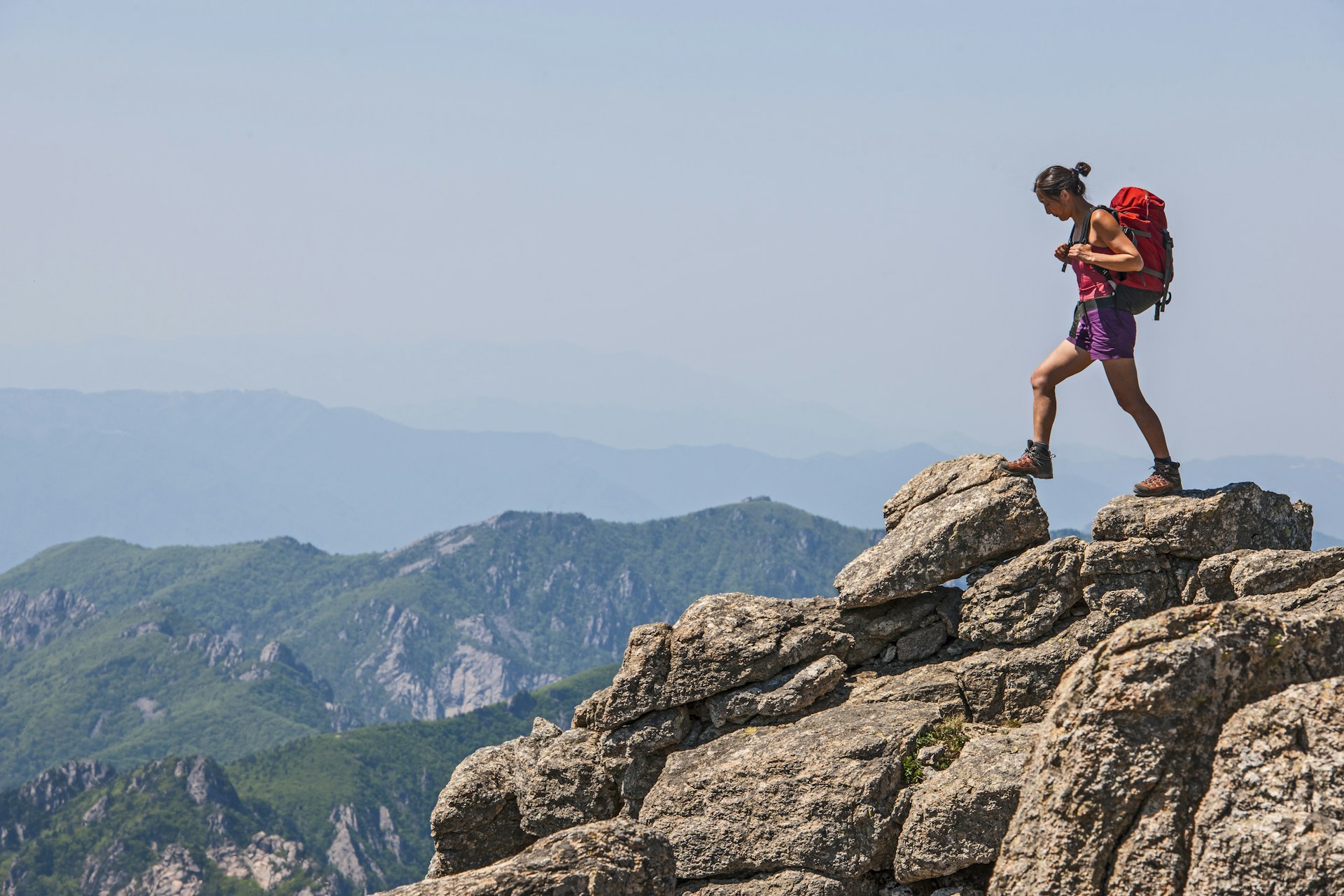 A woman walks across rocky terrain towards Daecheongbong peak at Seoraksan national park