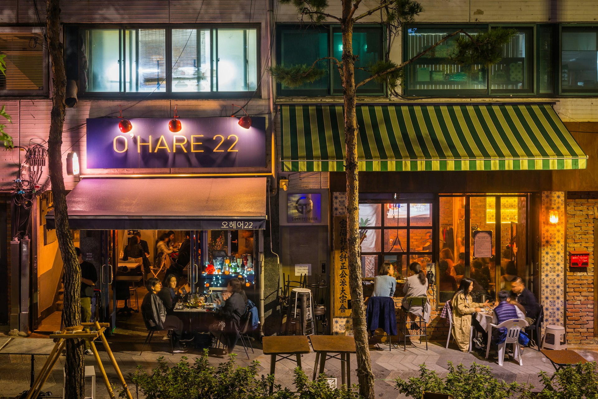 A street view of people inside and outside bars drinking at night in Seoul