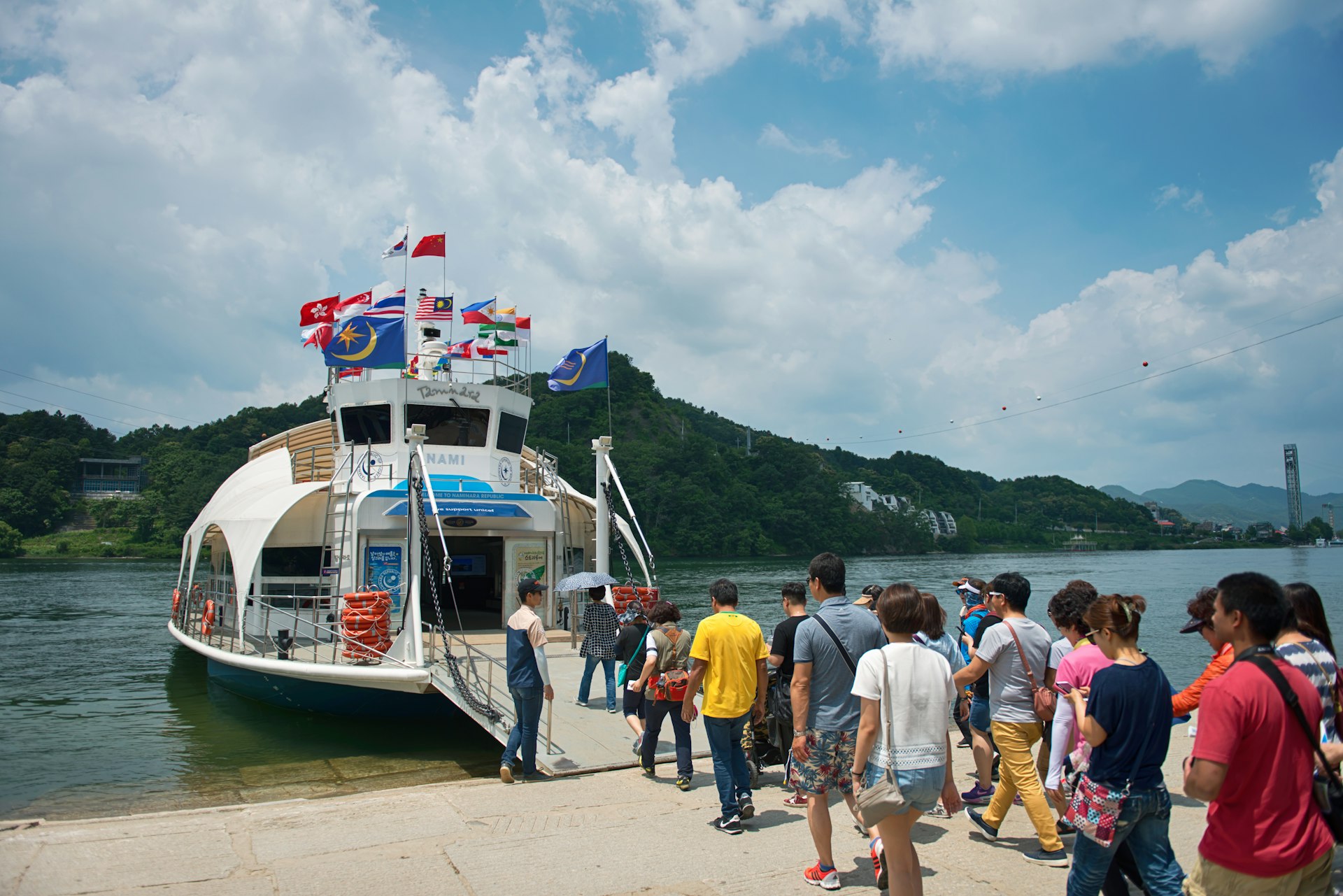 tourists Leaving the pier of Namiseom island and climbing aboard a ferry