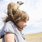 Five year old boy with Meerkat on his head, Kalahari Desert, Makgadikgadi Salt Pans, Botswana