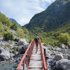 Rear view of man crossing bridge, Accursed mountains, Theth, Shkoder, Albania, Europe