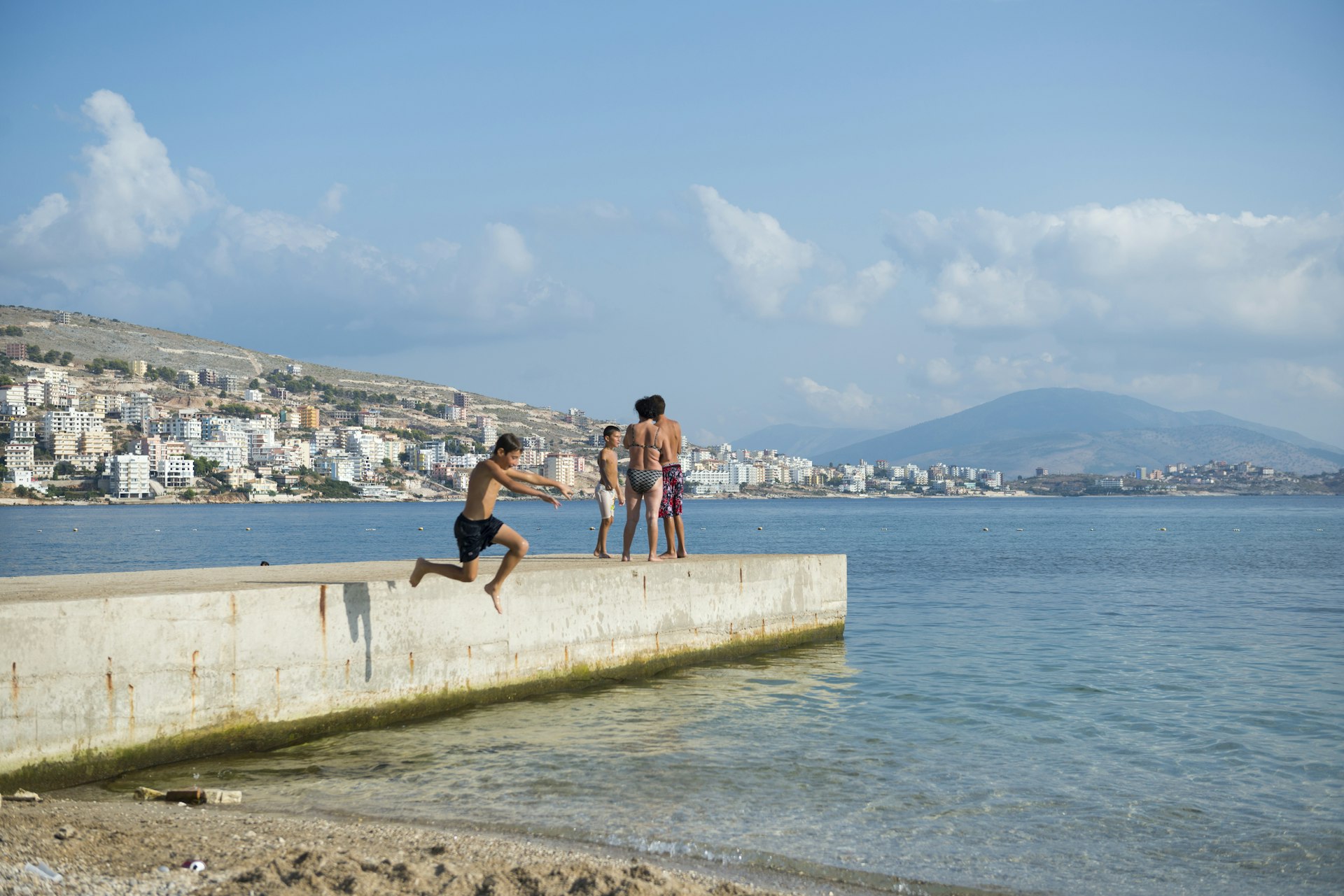 A boy jumps off a pier into the Mediterranean Sea in Sarande (Saranda), Albania 