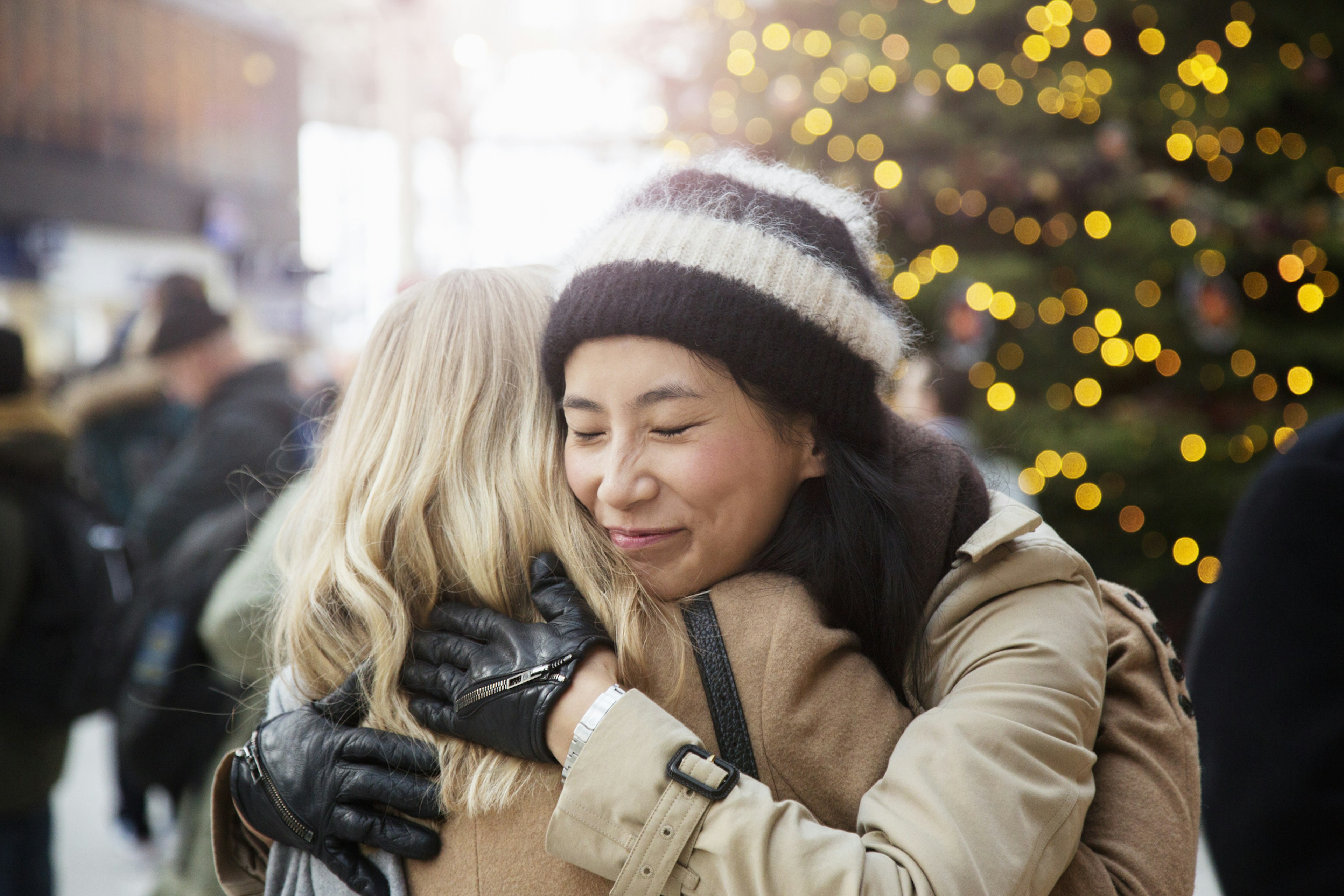 Friends embrace in railroad station at Christmas