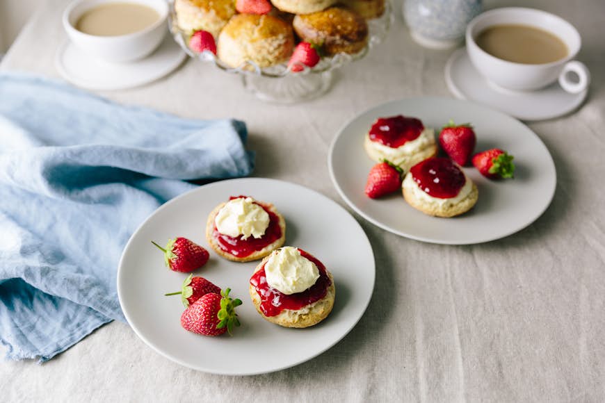 Scones with strawberries, jam, cream and a side of tea
