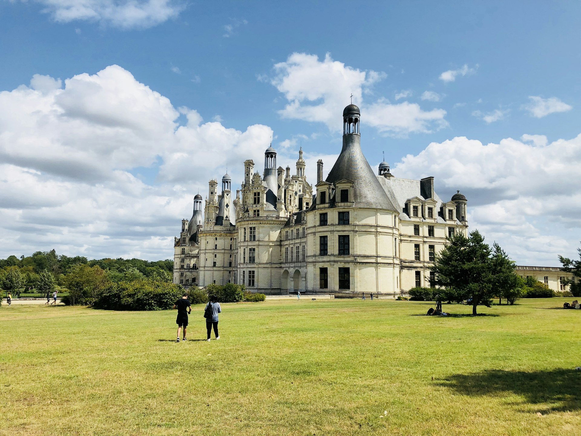 Two tourists admire the Chambord Castle in the Loire Valley