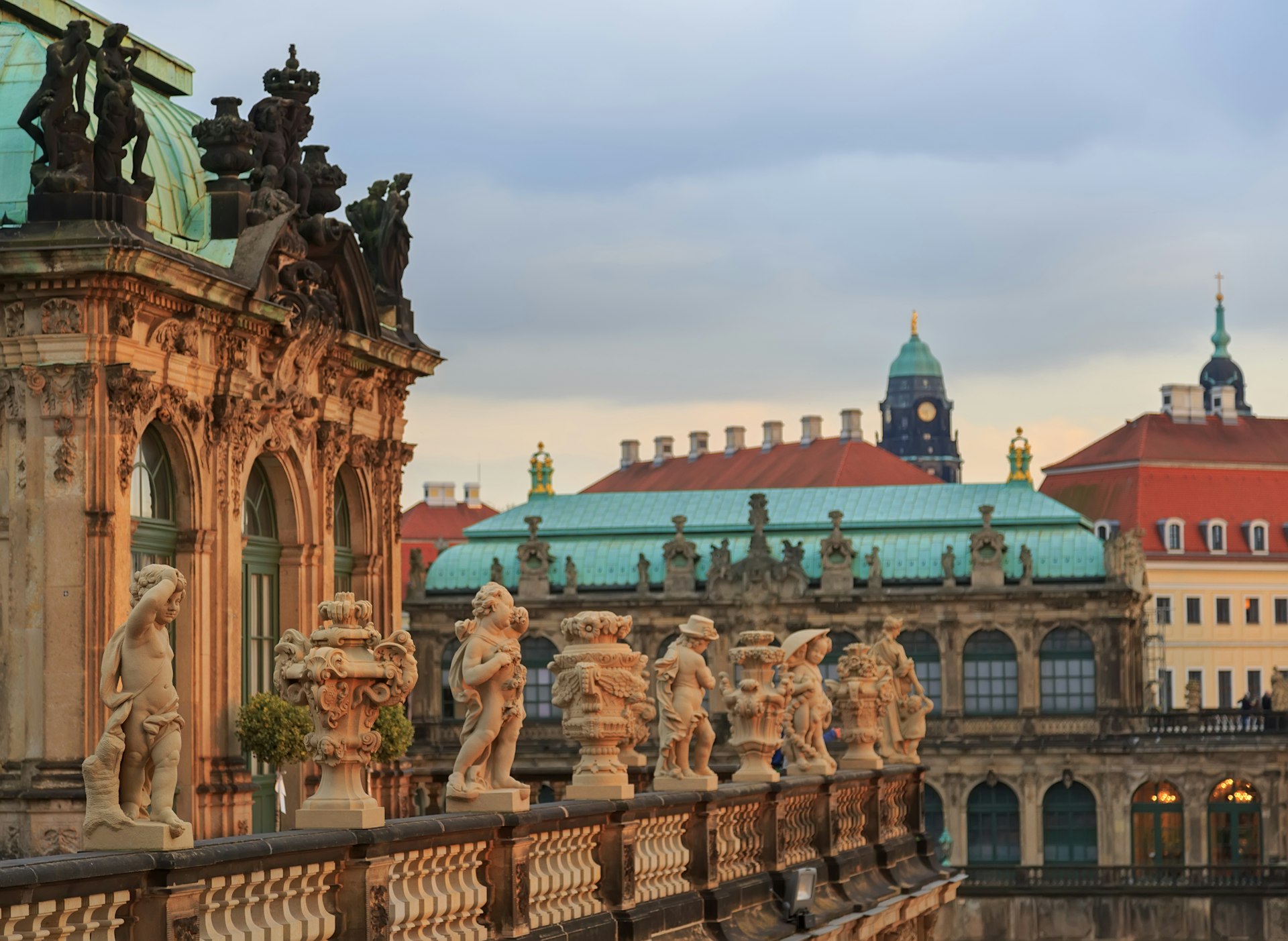 Rows of stone statues line the wall at the edge of a rooftop in Dresden