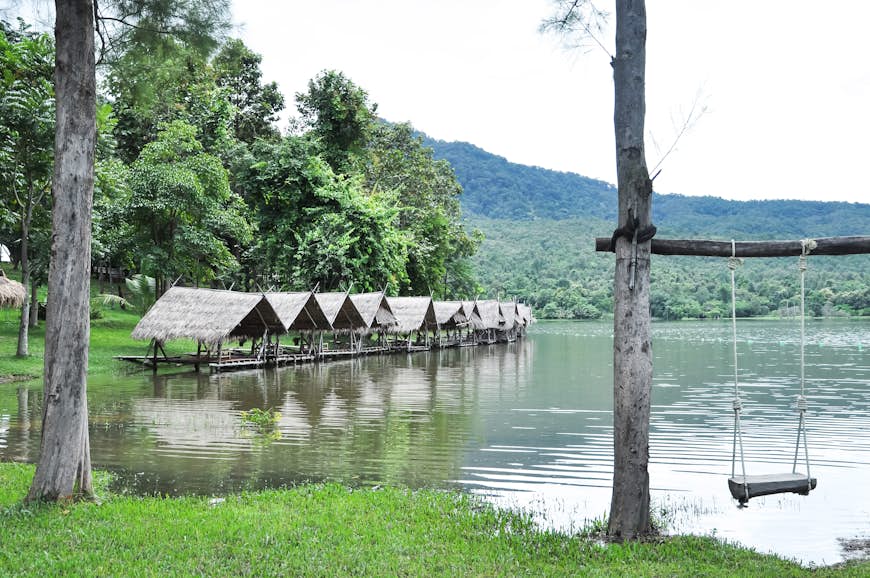 Wood swing with raft beside riverbank at Huay Tung Tao lake background in Chiang mai. Thailand