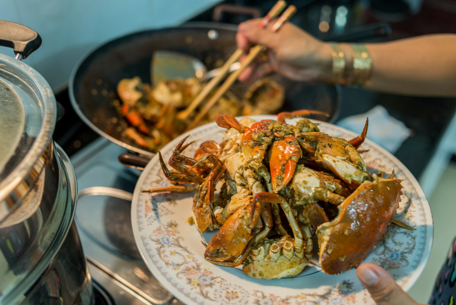 A lady prepares home-cooked chili crab for a family dinner.