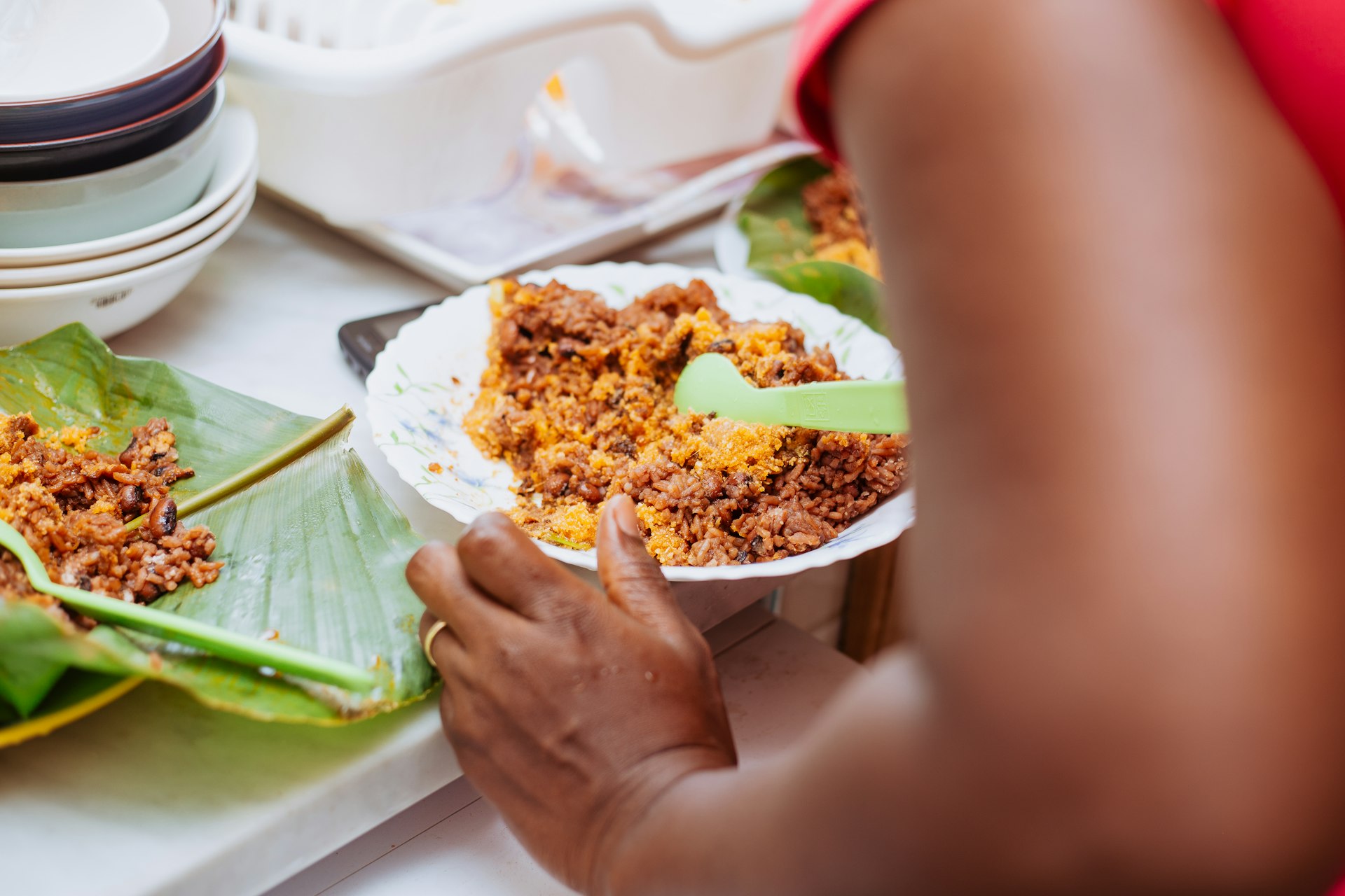 Cropped hands of woman having a plate of jollof rice at a table