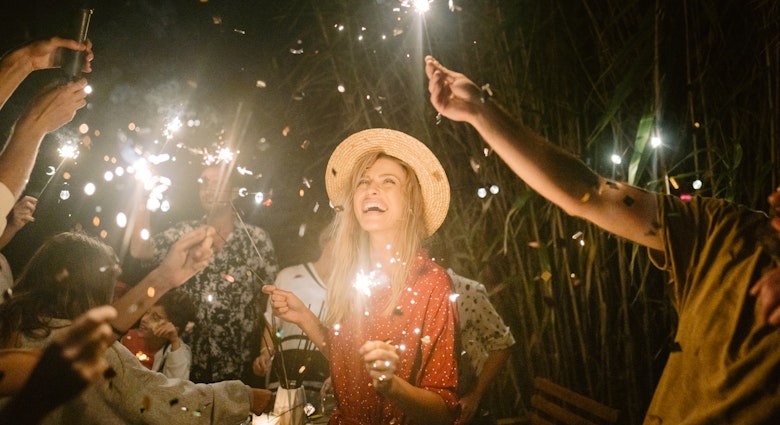 Photo of a young woman celebrating and having a summer dinner party with her family and friends.