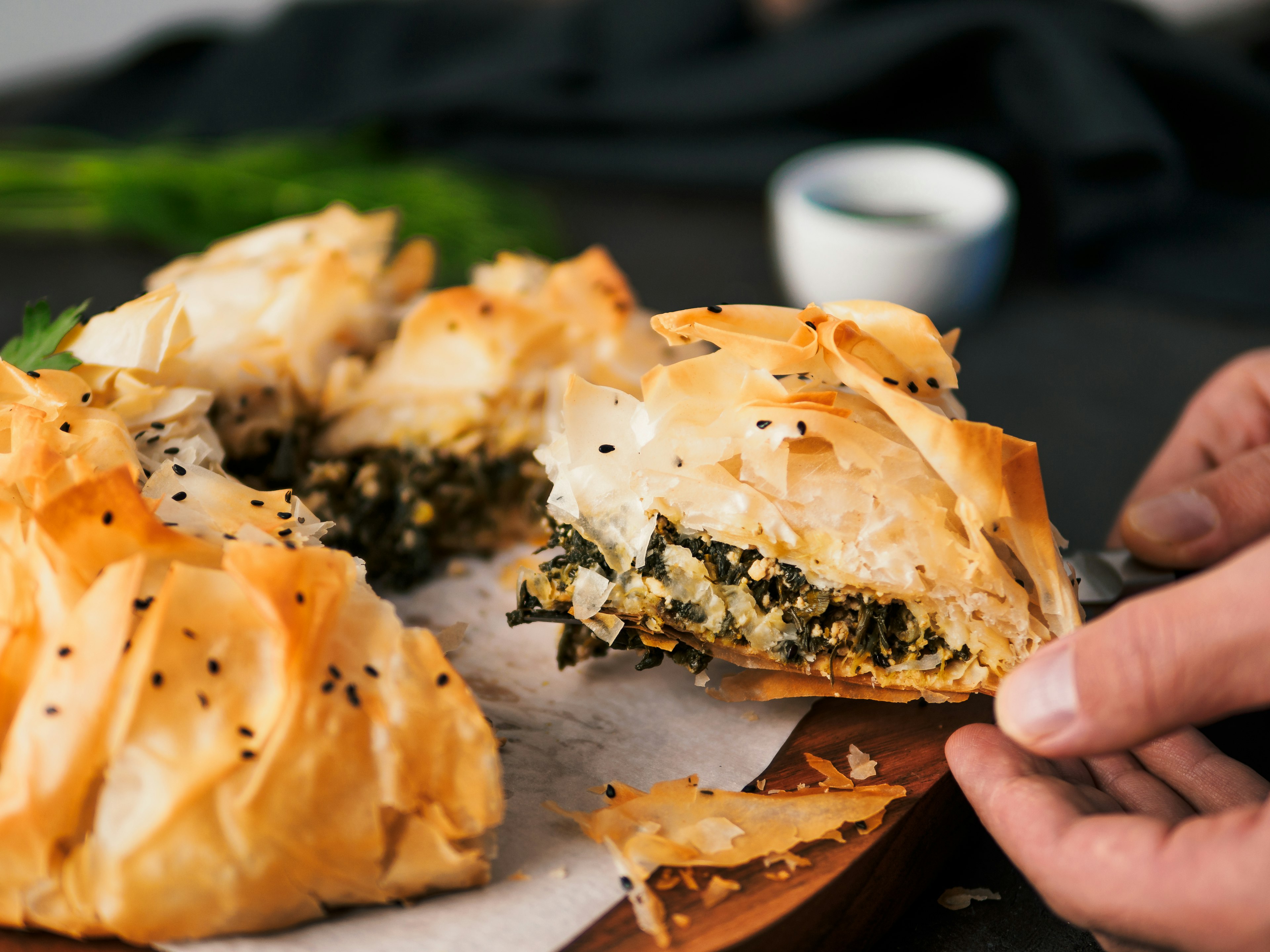 A slice of greek pie spanakopita in someone's hand