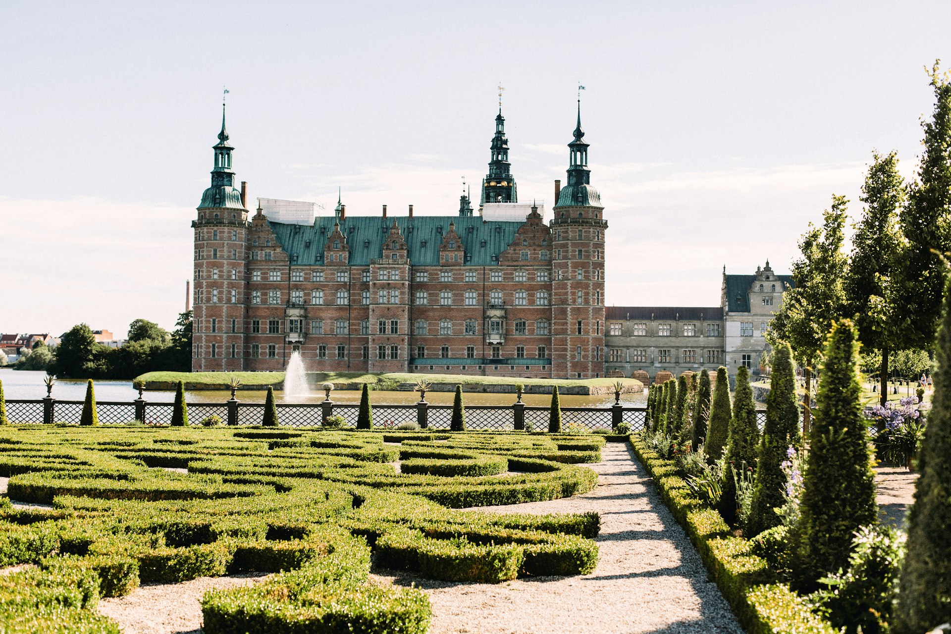 Frederiksborg Castle from a distance overlooking manicured gardens. In Hillerod, Denmark