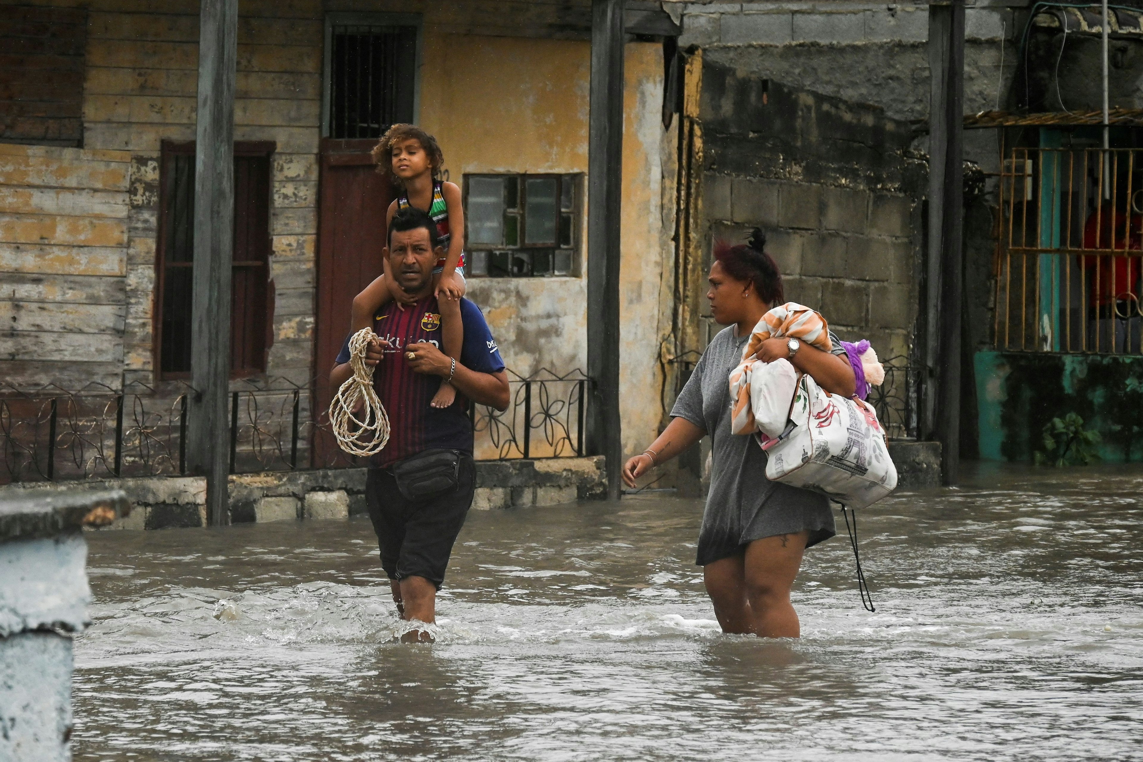 People walk through a flooded street in Batabano, Cuba