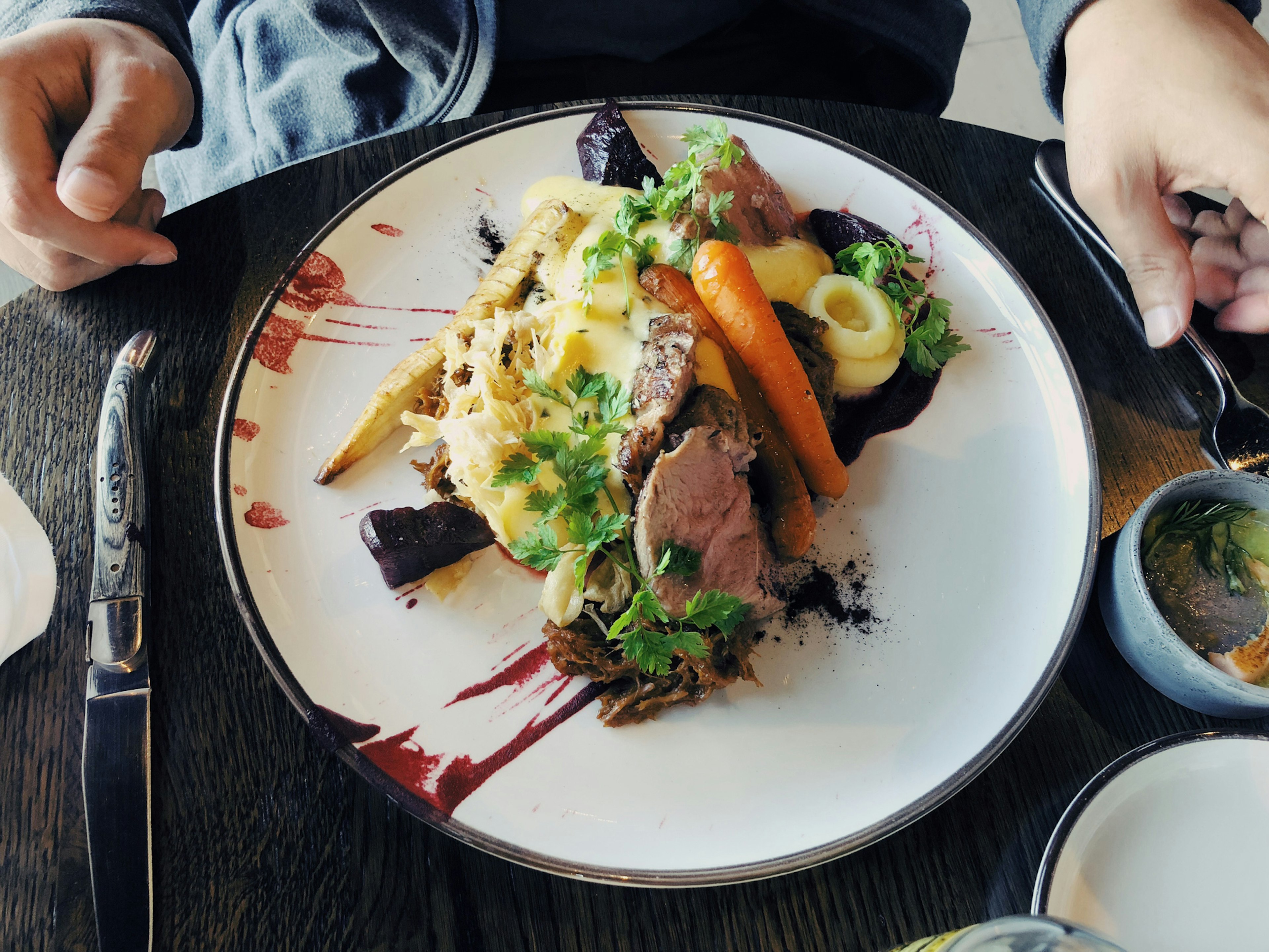 Man eating Icelandic dish: cooked lamb steak served with vegetables and mashed potatoes