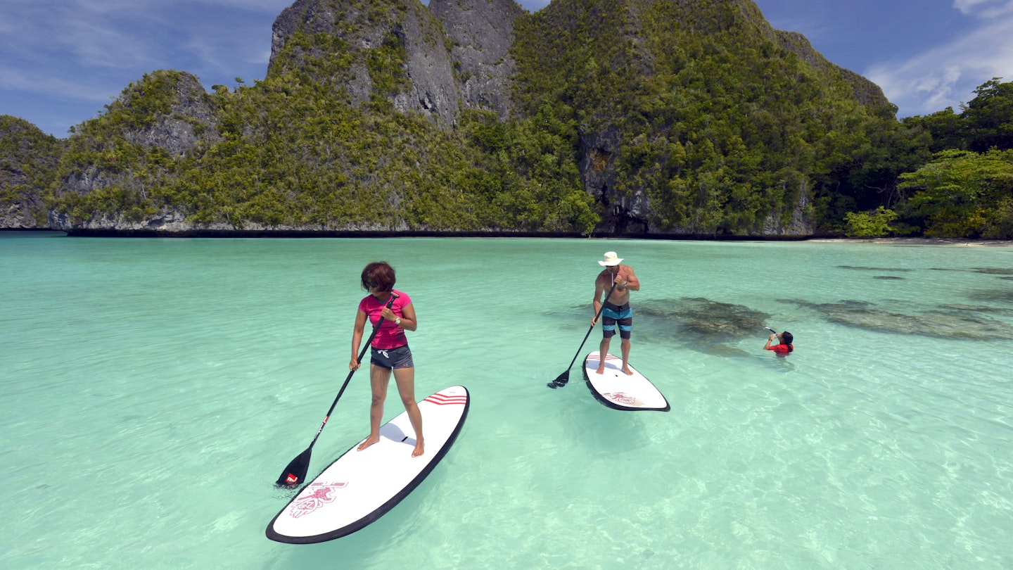 Tourists Stand up paddling in Wayag Island Raja Ampat Indonesia January 2016; Shutterstock ID 684582193; your: Sloane Tucker; gl: 65050; netsuite: Online Editorial; full: Raja Ampat Article