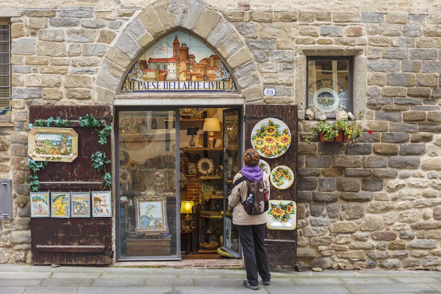 A woman looks at the exterior of a ceramics shop Deruta, Italy