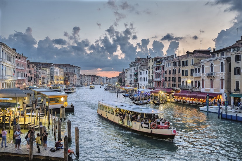 View from the Rialto Bridge of the Grand Canal of Venice with passing ferries at sunset