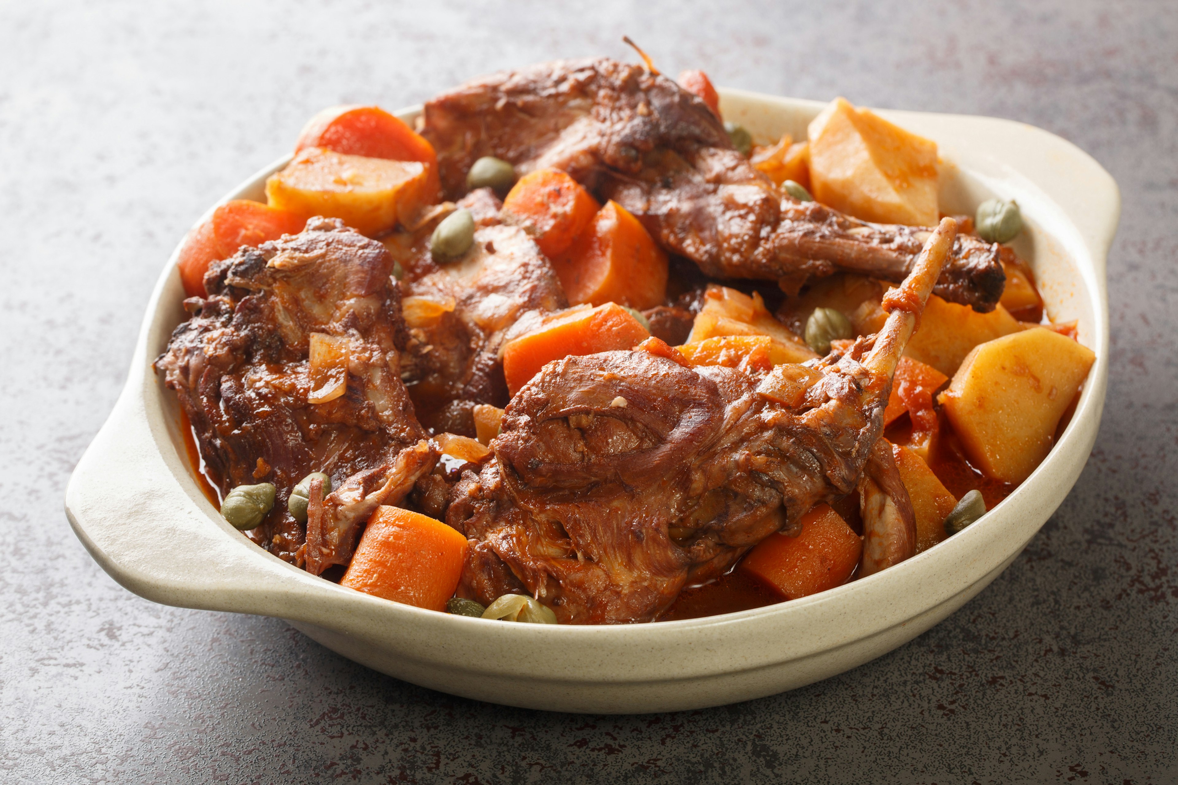 Rabbit Stew Maltese style or Stuffat tal-Fenek closeup in the pan on the table.