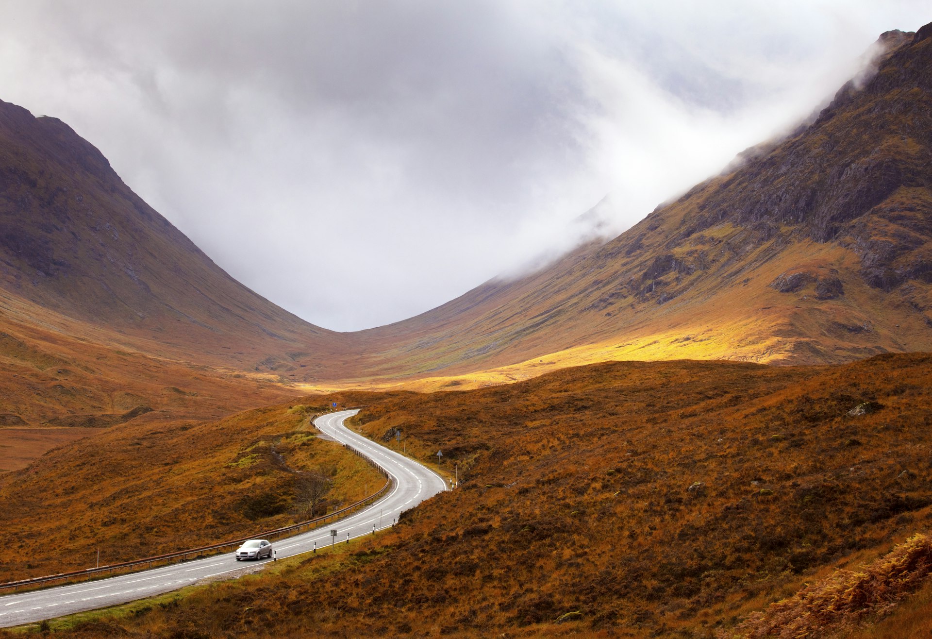 Winding road through the Scottish Highlands on a gray day in fall