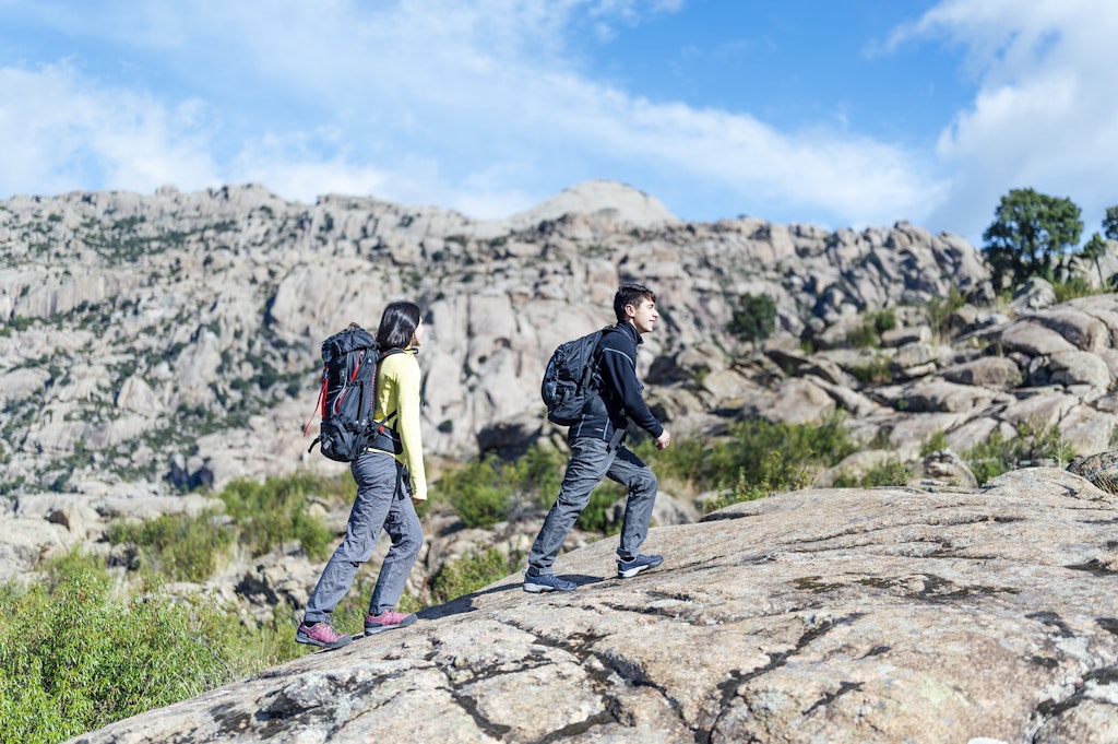 Young couple hiking on mountain trail . Spain, Sierra de Guadarrama.