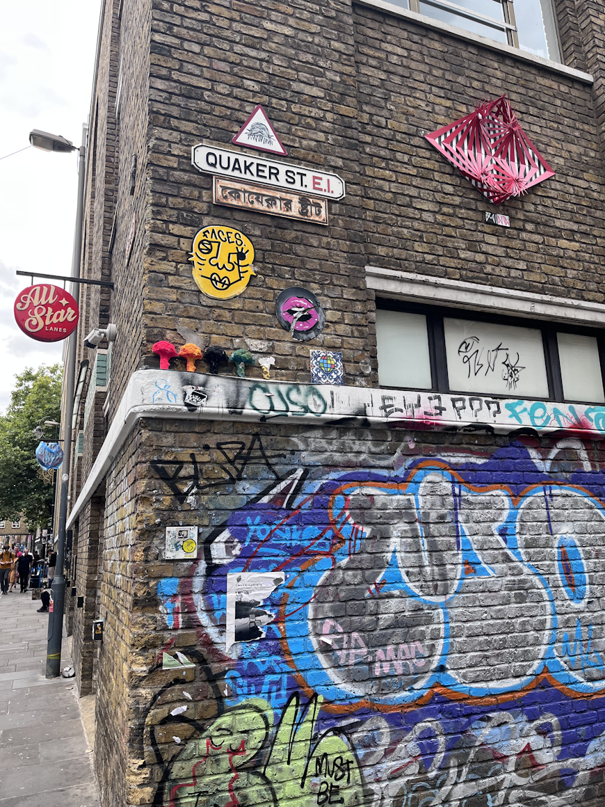 The street signs throughout Brick Lane feature plaques with the Bengali names for each street